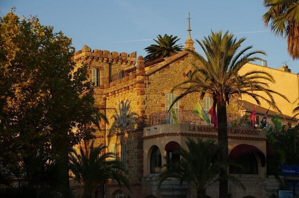 A historic stone building with a balcony and arches, named "LA MAISON DU LAVANDOU".