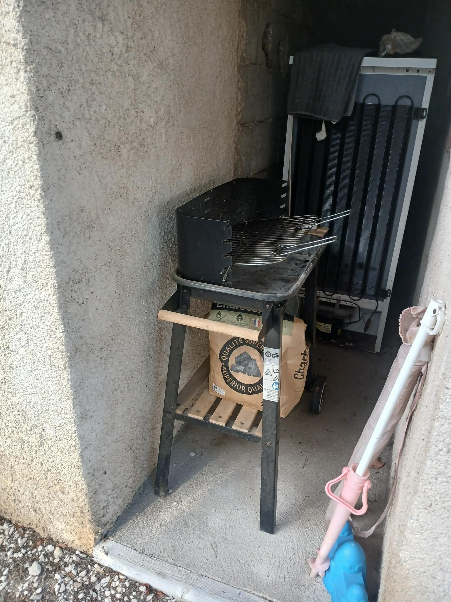 Ein kleiner Außenbereich zum Kochen mit Grill, Gaskocher und Holzkohlesack.