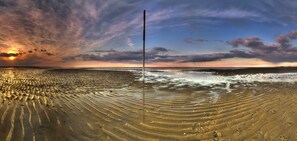 Ein Strand mit klarem Himmel und Sonnenuntergang.