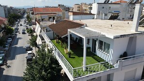 Een modern gebouw met een dakterras, inclusief een kleine tuin en een zitgedeelte buiten.