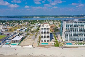 A coastal hotel with multiple buildings, a beach, and a marina.