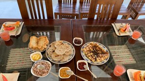 A dining table with various breakfast items including toast, pancakes, and fruit. - villacork face the river (Galle)