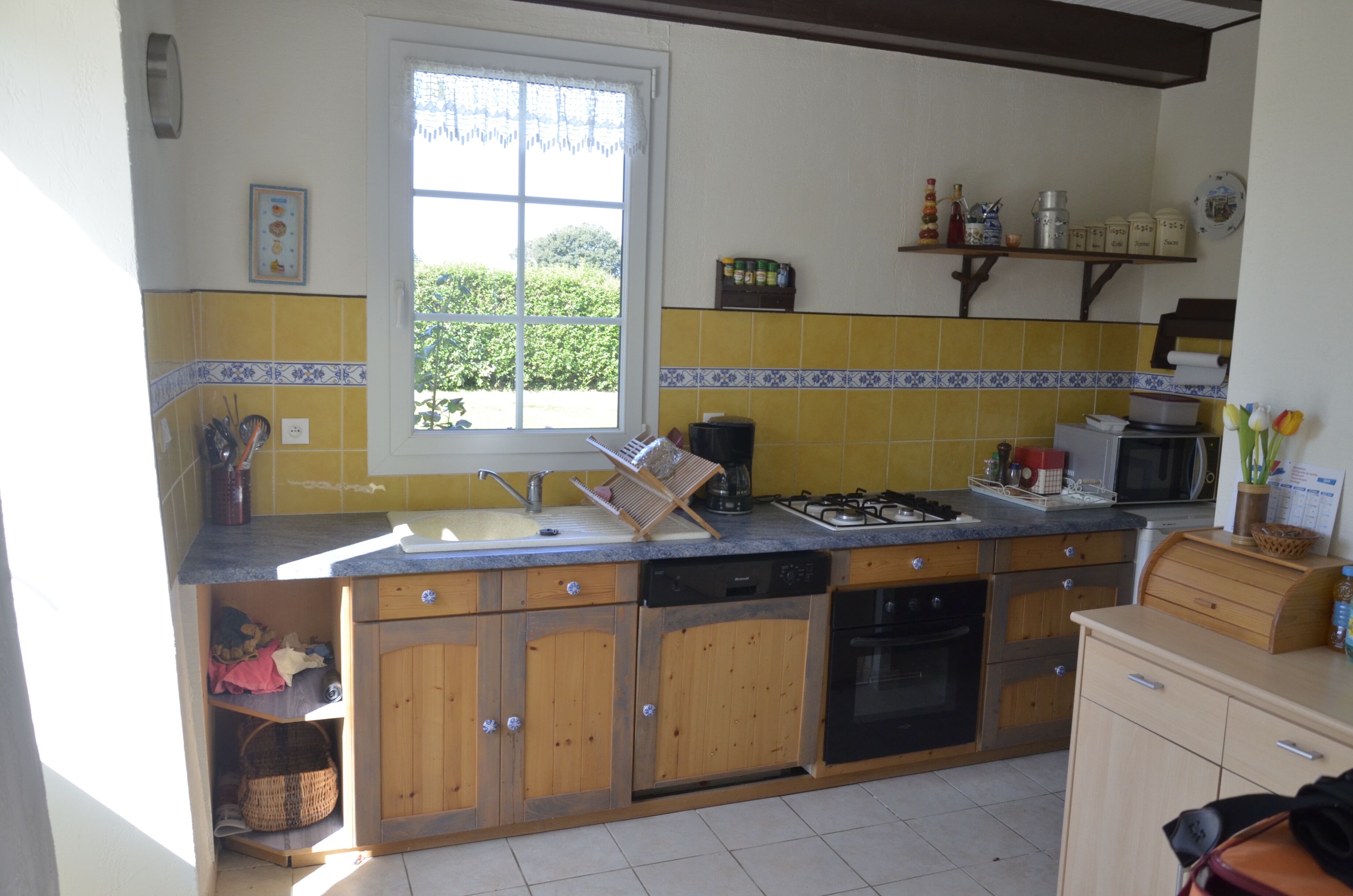 A kitchen with wooden cabinets, a sink, a stove, and a window.