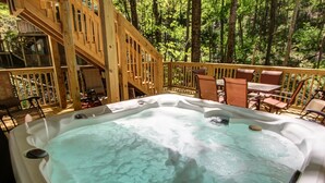 Un jacuzzi rodeado de mobiliario de madera y una escalera.