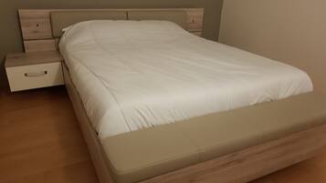 En säng med en träram och en beige madrass.