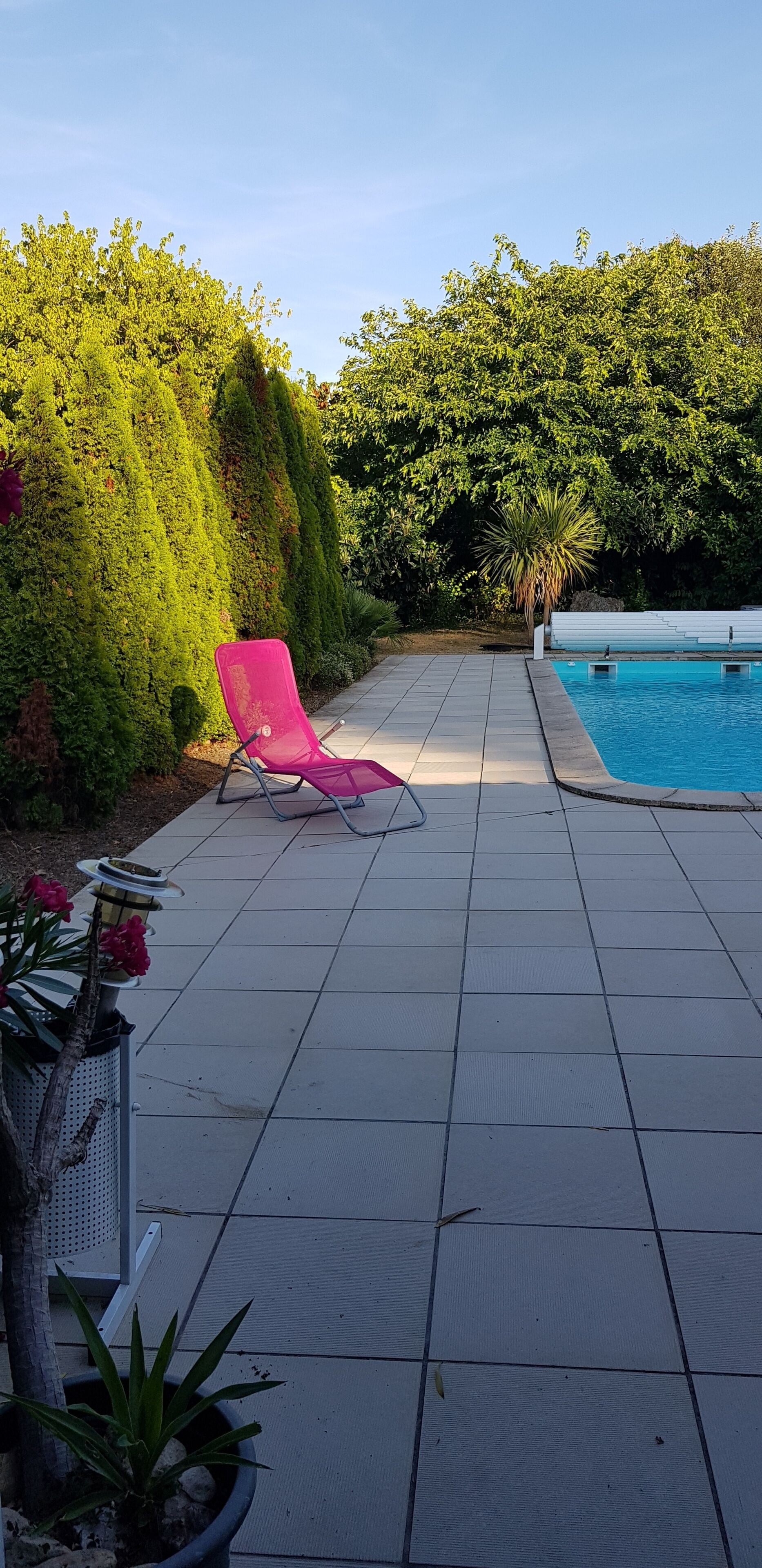 Una piscina al aire libre de temporada, sillones reclinables de piscina