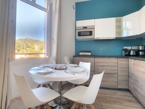A modern kitchen with white cabinets, a built-in oven, and a coffee maker.