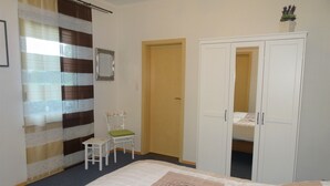 Une chambre à coucher avec un lit, une chaise, une armoire et une porte.