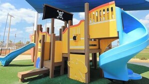 Ein Spielplatz mit einer Piraten-Spielanlage, einschließlich Rutschen und Kletterbereichen.