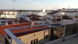A rooftop terrace with tiled flooring and a metal railing. - Apartment with balcony and terrace near the center and the beach (Royan)
