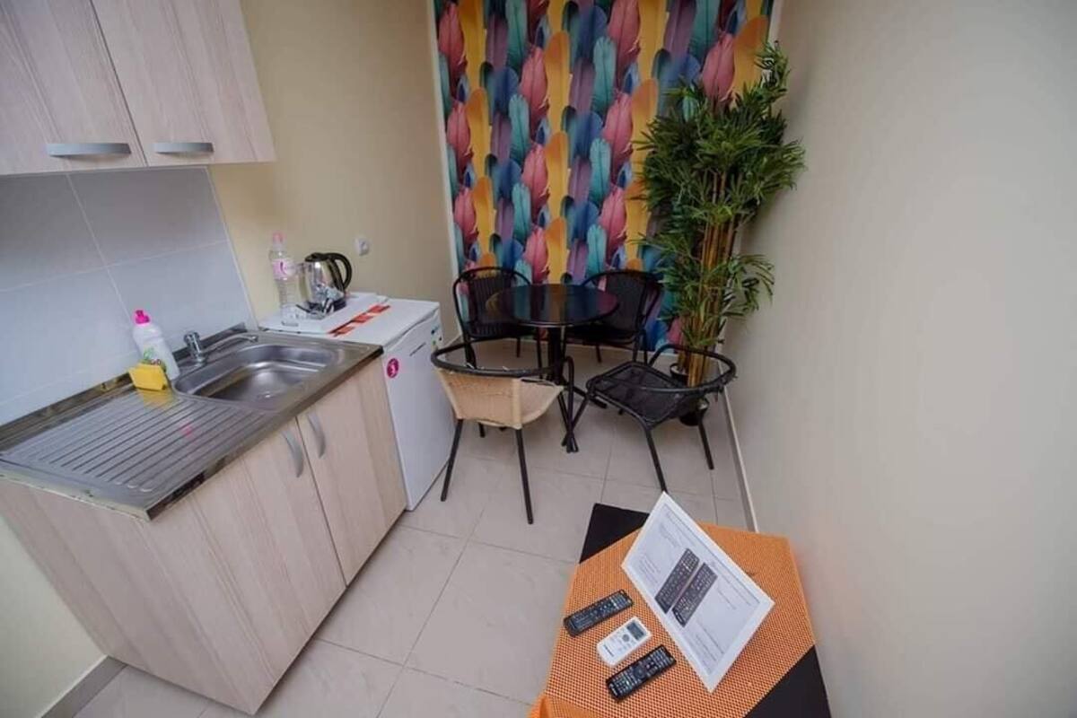 A compact kitchen with a sink, a small dining area with chairs, and a table with a menu.