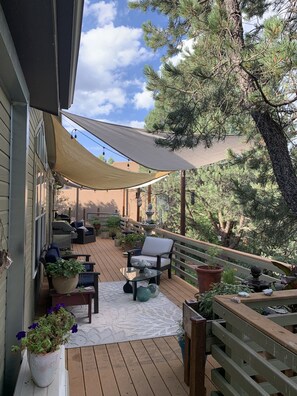 A wooden deck with outdoor furniture, a pergola, and potted plants. - Birdsong by day, daimond lit sky by night (Sedona)