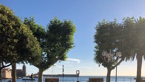 A paved walkway with stone bollards, a bench, and potted plants. - Charming in Collioure – where creativity meets the beach (Collioure)