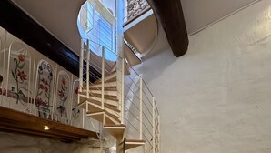 A spiral staircase in a room with a white wall and a circular skylight. - Charming in Collioure – where creativity meets the beach (Collioure)