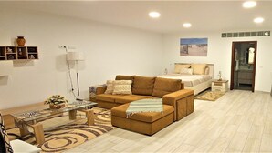 Een moderne woonkamer met een bank, een salontafel en een eethoek met stoelen.