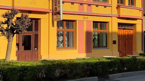 A yellow building with multiple windows and a sign indicating it is a hotel. - Hotel U Beránků (Libochovice)