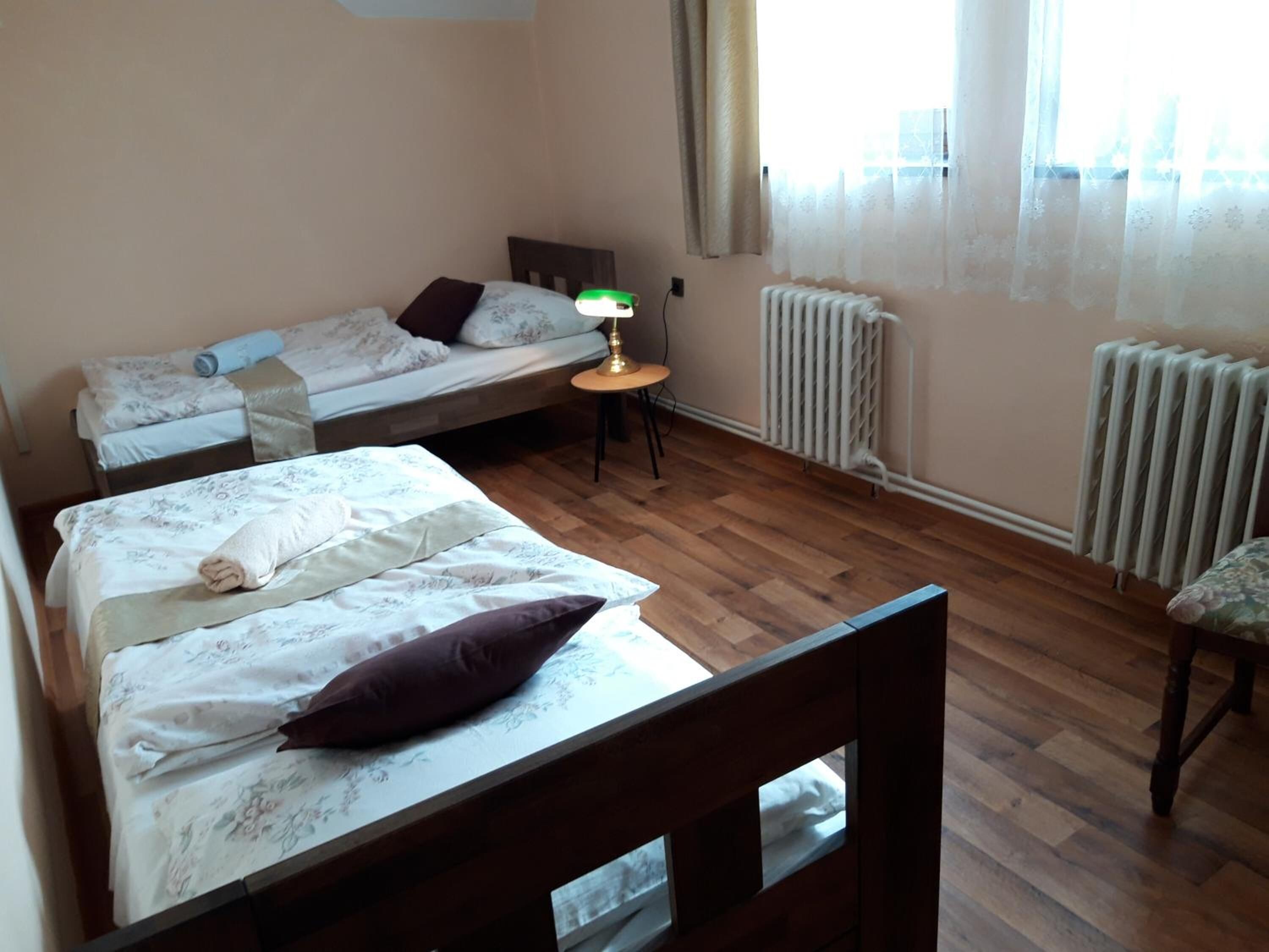 A room with two beds, a small table, and a chair.
