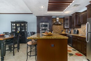 Enjoy cooking in this well-equipped kitchen with a central island, sink, and stainless steel appliances.