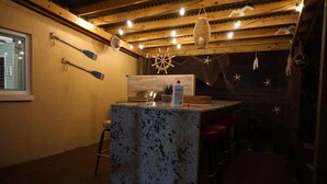 Tunnelmallinen baarialue, jossa on puinen katto, valoketjut ja merellinen sisustus.