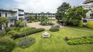 A courtyard with a picnic table, bicycles, and a covered bike shed. - Blue Shell With Private Parking Garage (Zandvoort)