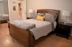 A neatly made bed with a wooden headboard, two bedside tables with lamps, and a mirror on the wall. - COZY NORTH PHX 2 BR CASITA, Trailer parking and near MAYO Clinic (Phoenix)