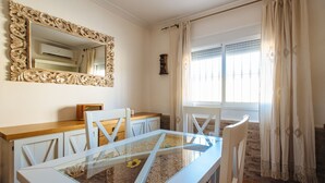 A dining area with a glass table, white chairs, a wooden counter, and a large ornate mirror on the wall. - Villa Los Naranjos, oasis with jacuzzi 15 minutes from Seville (Almensilla)