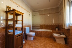Tina con regadera, secadora de cabello, bidet, toallas 