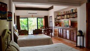 A room with two beds, a dining area, and a kitchen with a TV. - Beach FrontFully  Equipped Suite # 4 (Centro - Supmza. 001)