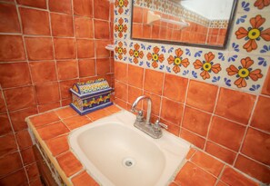 A bathroom with a sink, tiled walls, and a decorative tile border. - Beach FrontFully  Equipped Suite # 4 (Centro - Supmza. 001)