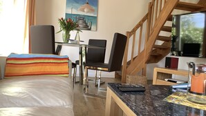 A hotel room with a bed, a desk, a chair, a TV, and a staircase. - Maxe house, Paula house - golf course, beach and surfing area within walking distance (Wulfen)