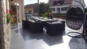 An outdoor patio with dark wicker furniture and a hanging chair. - Thermal Panzió Sárvár (Sarvar)
