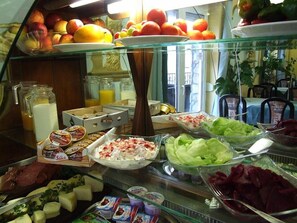 Un bufé de desayuno con una variedad de alimentos, incluyendo frutas, verduras y productos lácteos.