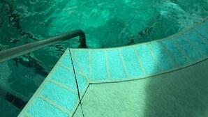 A hot tub with a tiled edge and a metal ladder. - Perfect Vacation Getaway! Beach Condo in Quiet Setting, CLOSE TO THE BEACH! (Myrtle Beach)