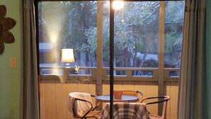 A room with a sliding glass door leading to an outdoor seating area with a table and chairs. - Perfect Vacation Getaway! Beach Condo in Quiet Setting, CLOSE TO THE BEACH! (Myrtle Beach)