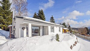 A modern white house with large glass doors and windows, surrounded by snow and trees. - Cozy home in Goldlauter-Heidersbach (Goldlauter-Heidersbach)