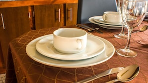 A dining table set with white plates, a cup, a glass, and silverware. - Fonte da Rosa Guest House APT2 (Belmonte)