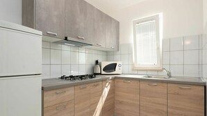 A modern kitchen with a gas stove, a microwave, and a sink. - Lovely apartment in villa for 5 guests with WIFI, A/C, TV and terrace (Umag)