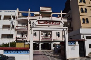A hotel entrance with a sign reading "HOTEL COTE OUEST".