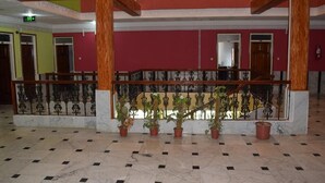 Eine Lobby mit Marmorboden, einer Holztreppe und Topfpflanzen.