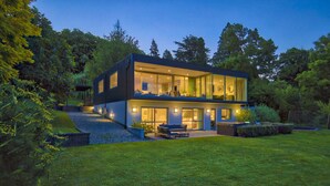 A modern two-story house with a spacious outdoor area, including a patio and a small garden.