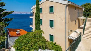 Un immeuble doté d’un balcon, offrant une vue sur la mer et s’ouvrant sur un ciel dégagé.