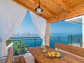 Enjoy the serene view of the water from this balcony, complete with a refreshing drink and a place to sit.