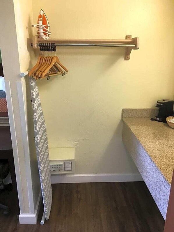 Un baño pequeño con un perchero de madera, un toallero y una cortina de ducha.