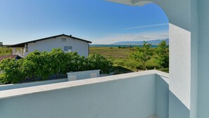 A balcony with a view of a white house and a grassy field. - Lovely apartment for 5 people with pool, A/C, WIFI, TV, balcony and pets allowed (Zadar)