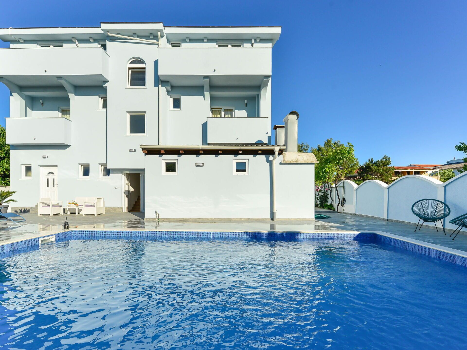 A modern two-story building with a swimming pool in front.