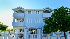 A multi-story building with balconies, a gated entrance, and flower planters. - Lovely apartment for 5 people with pool, A/C, WIFI, TV, balcony and pets allowed (Zadar)
