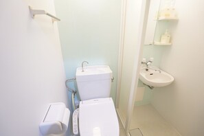 Une petite salle de bain comprenant des toilettes, un bidet et un lavabo.