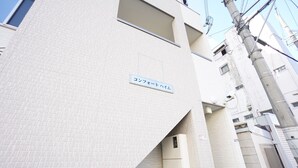 A building with a sign reading "コンフェートハイム". - Terry's Apartment Namba South V C01F (Osaka)