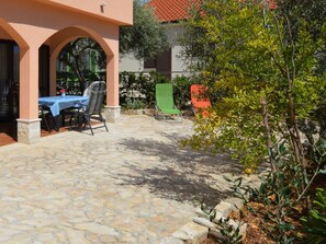Relax on the patio surrounded by lush greenery and enjoy a meal at the table for two.