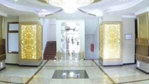 A grand lobby with a chandelier, marble flooring, and ornate wall panels. - Safran Hotel (Baku)